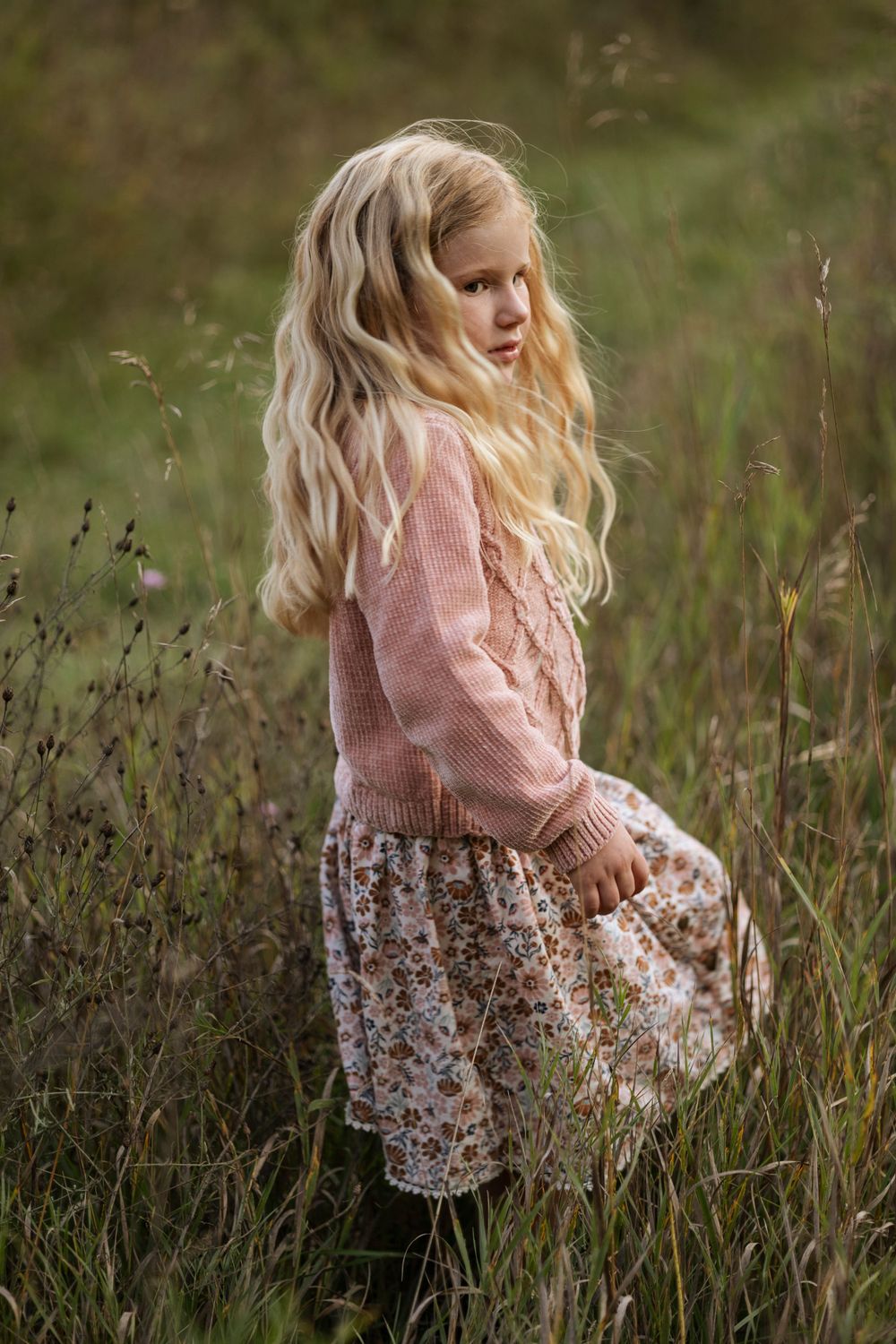 Blonde little girl in a field of grass.