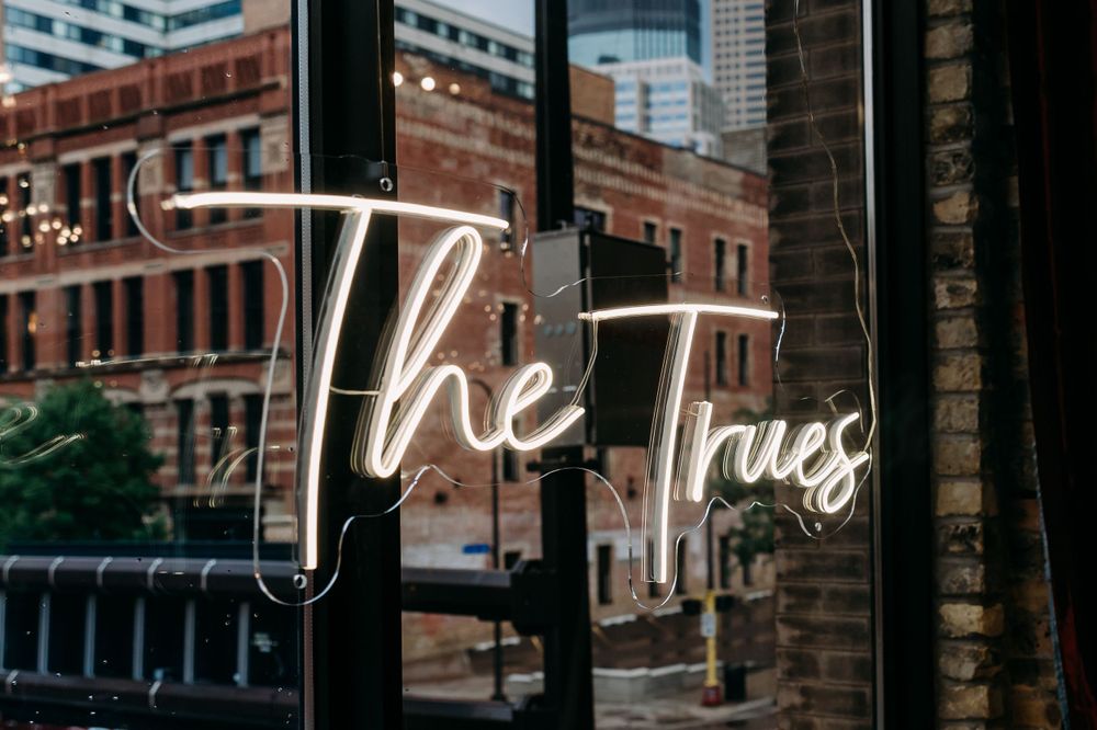 Urban cityscape with neon signage visible through window reflections.