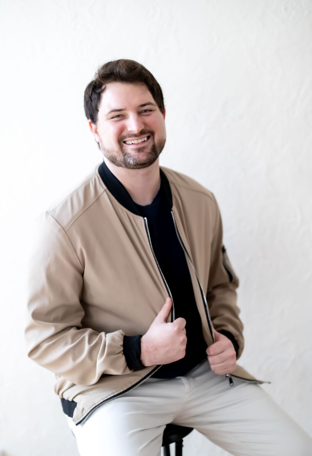 Professional headshots of person in beige jacket against white background.