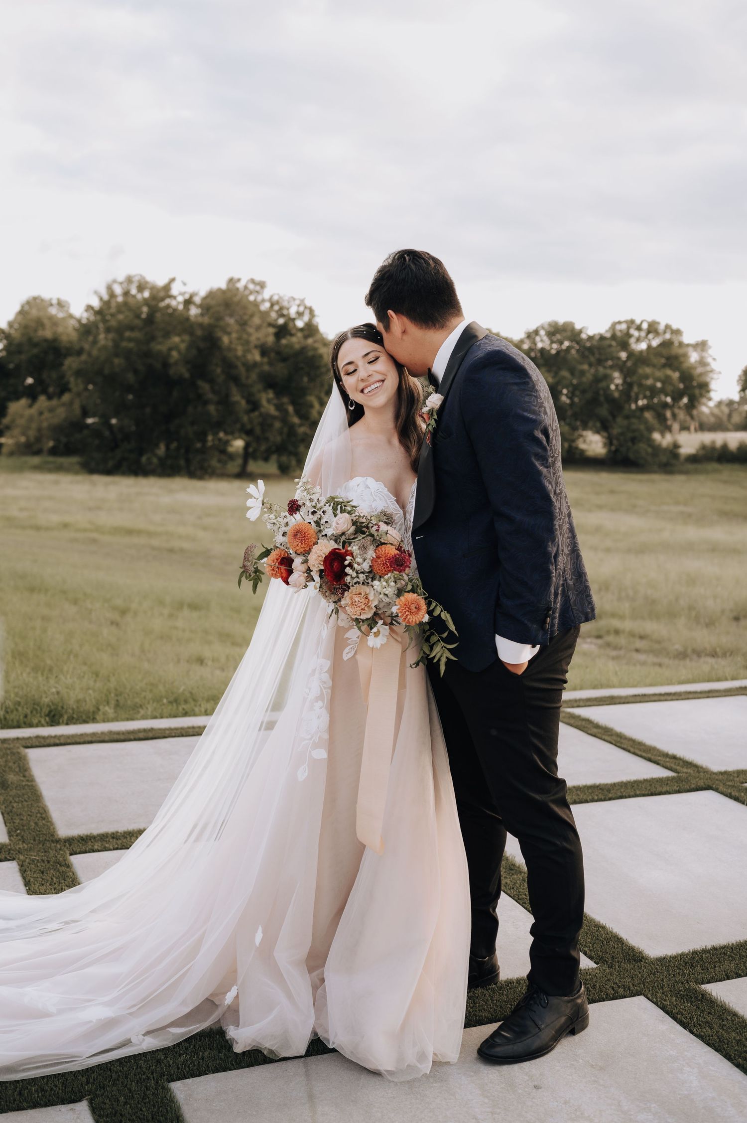Wedding couple shares an intimate moment on a modern geometric outdoor platform.