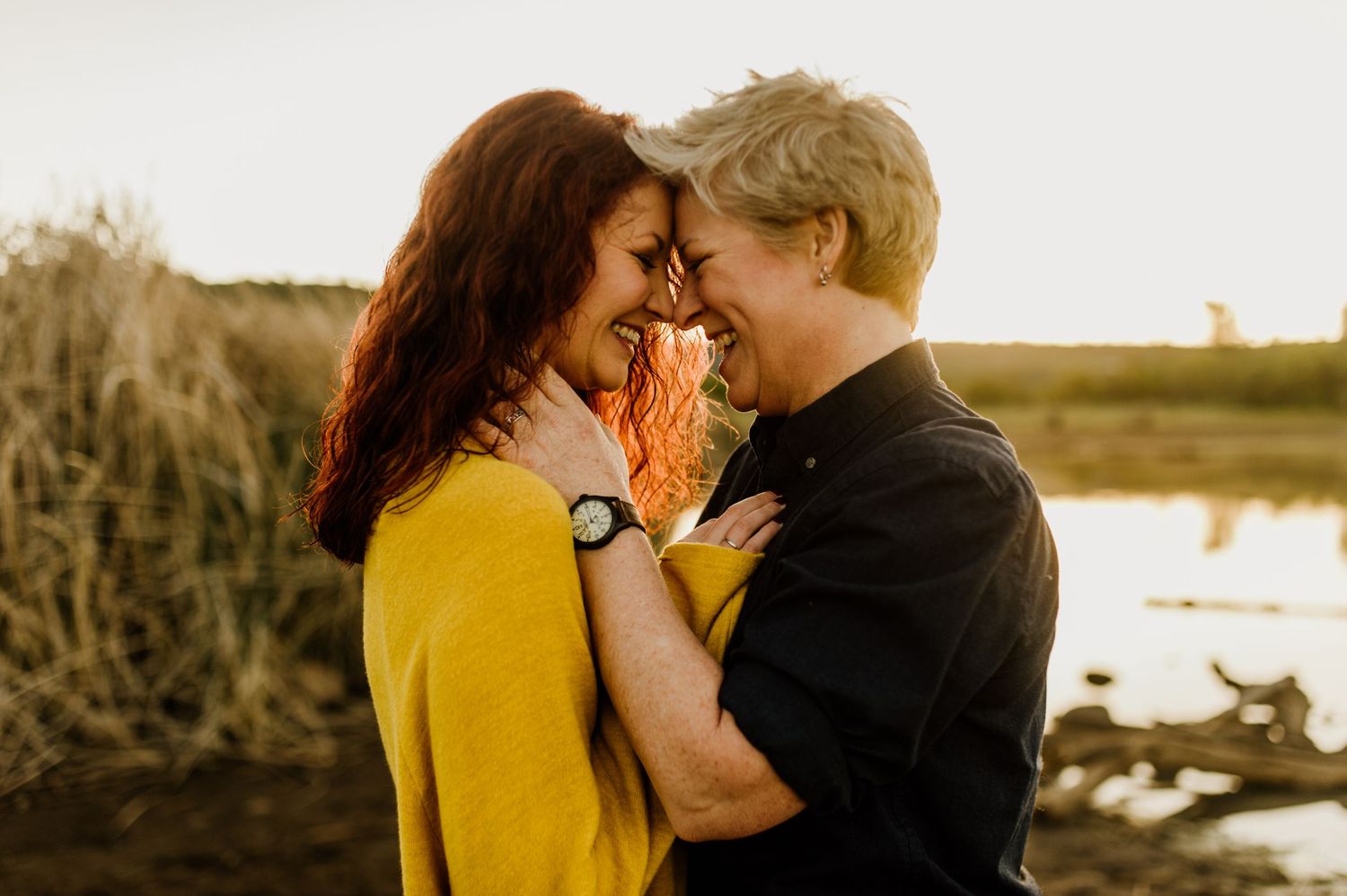 Romantic sunset portrait of couple embracing outdoors with golden hour lighting.