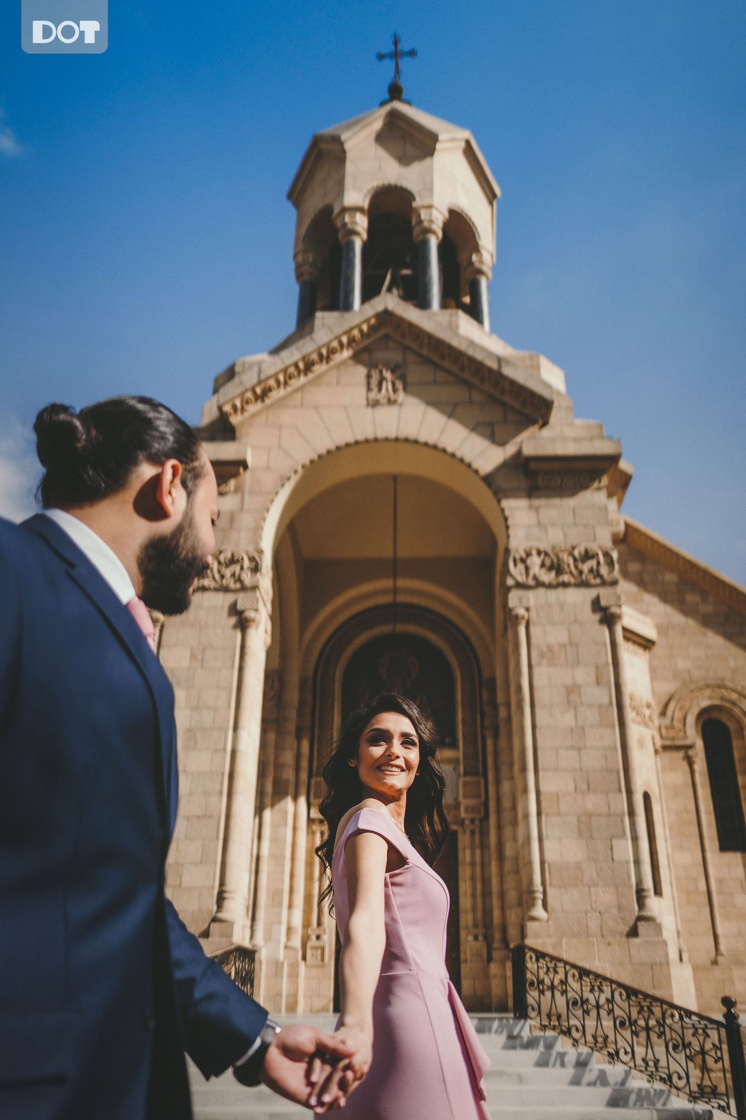 Wedding photos taken outside a traditional Armenian church with stone architecture.