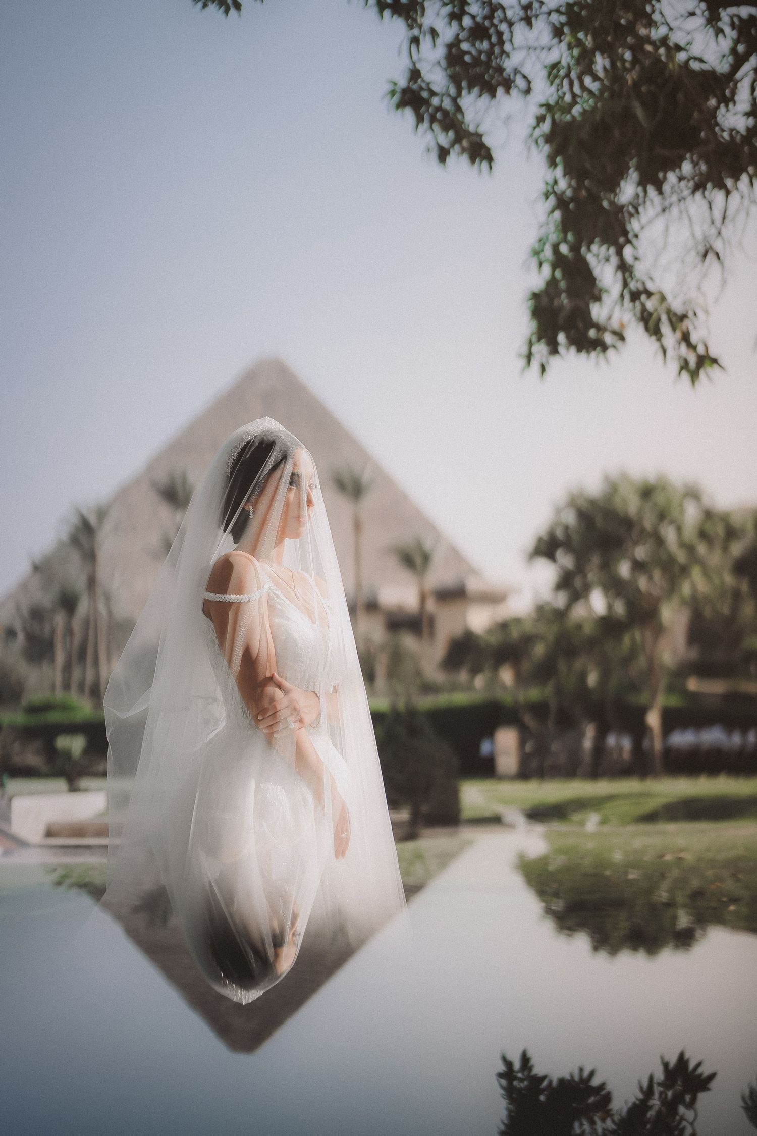 Creative double exposure of bride against geometric pyramid architecture.