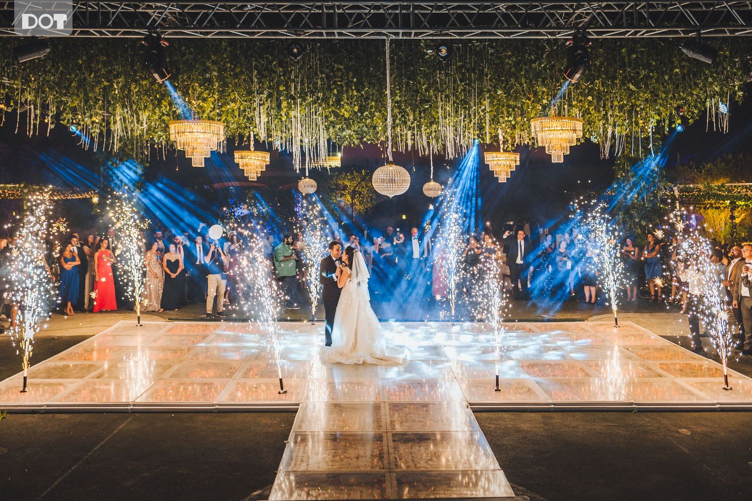Wedding reception venue with dramatic lighting and fountain effects creating magical atmosphere.