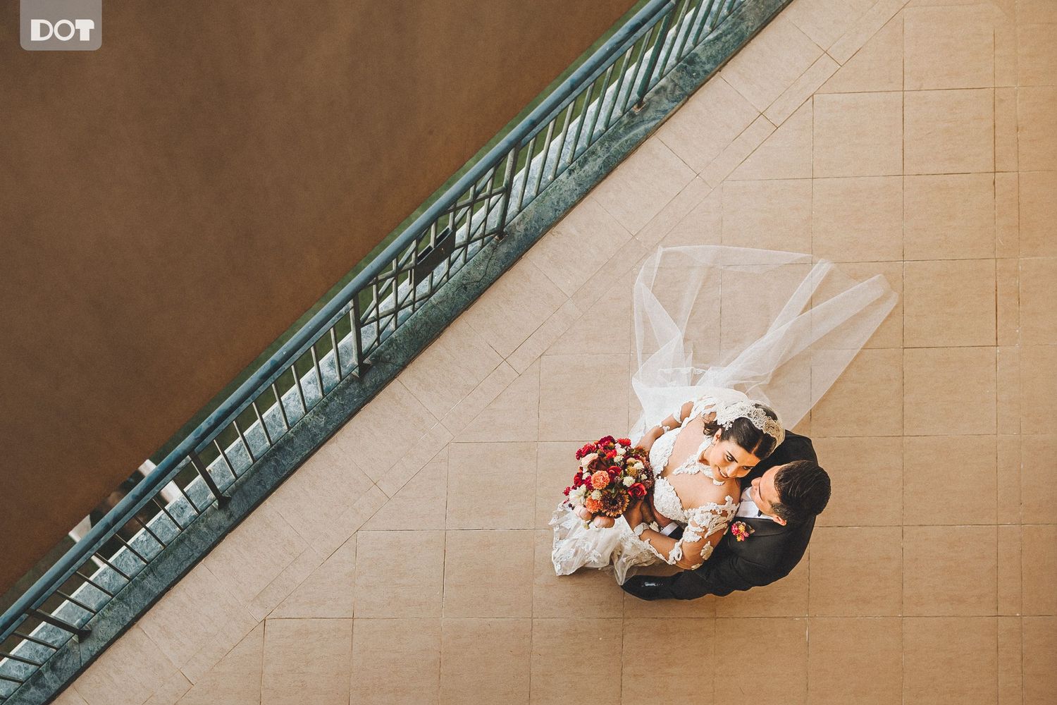 Wedding dress train trailing elegantly down marble staircase.