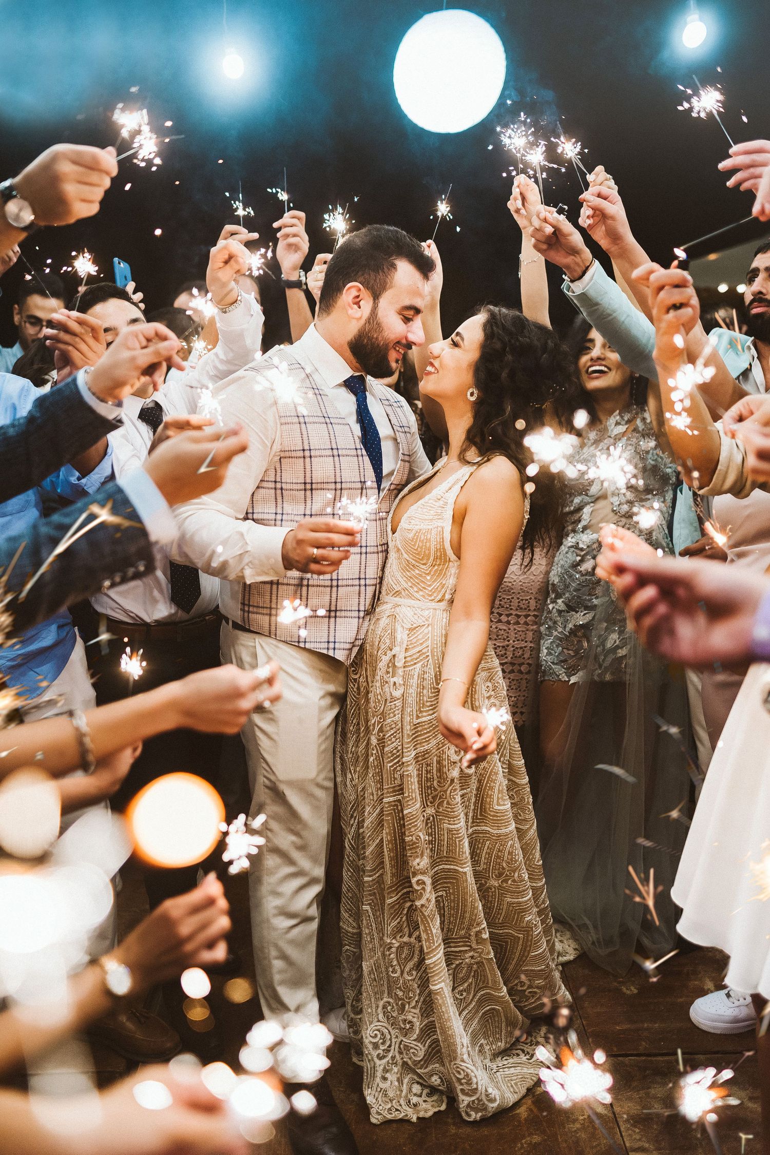 Wedding celebration with sparklers creating magical light effects during evening reception.