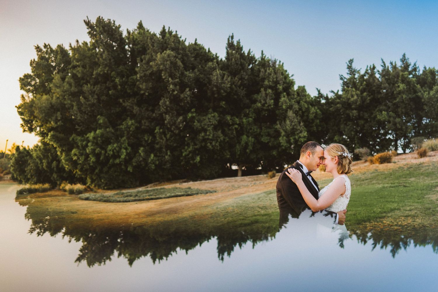 Wedding couple silhouetted against scenic mountain landscape at sunset.