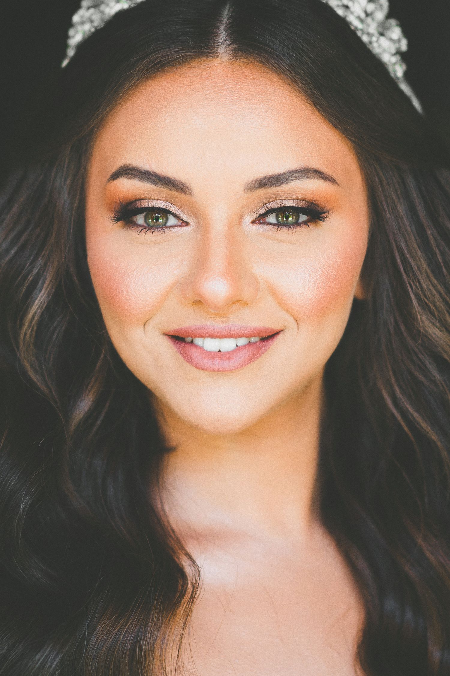 A close-up beauty portrait wearing a delicate tiara and natural makeup.