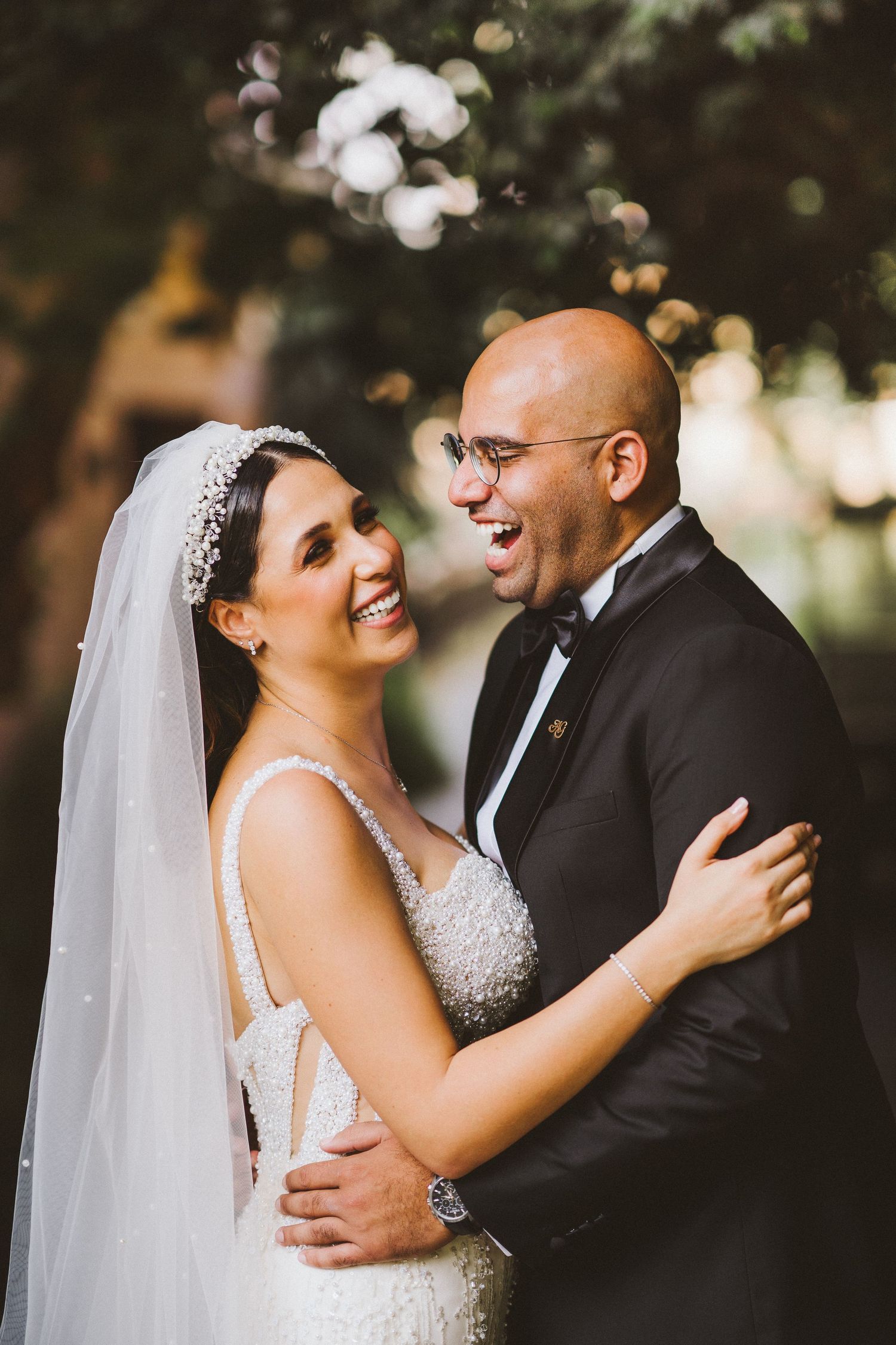 Wedding couple shares genuine laughter during outdoor portrait session.