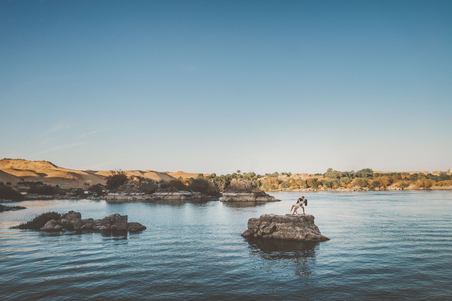 Serene seascape with rocky formations jutting out of calm blue waters.