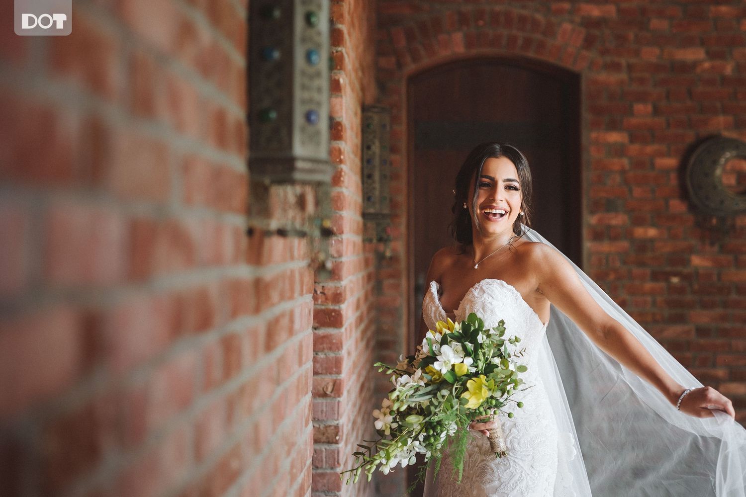 Elegant bridal portrait against rustic brick wall with natural lighting.