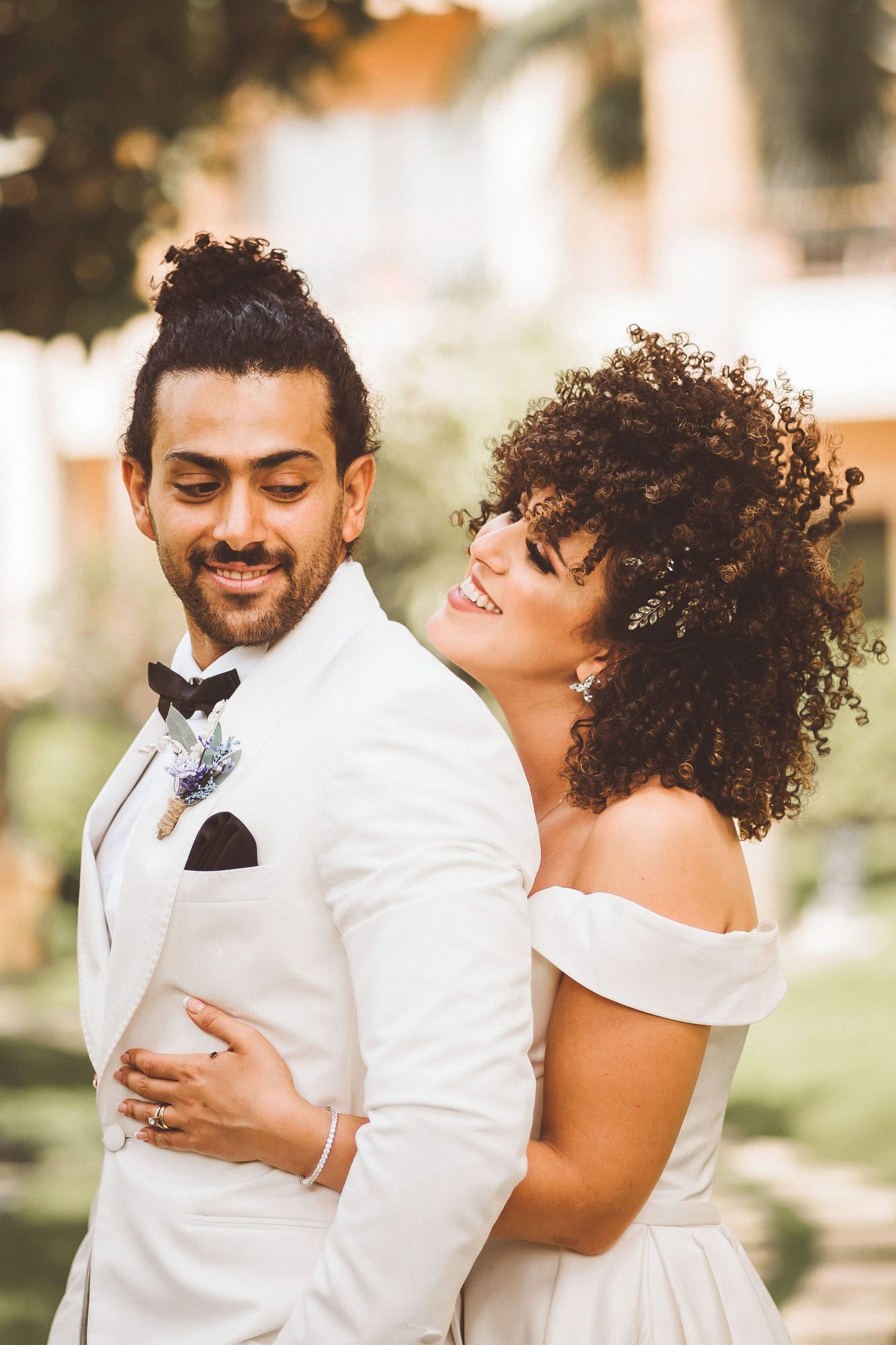 Candid moments of laughter and joy between couple in white wedding attire.