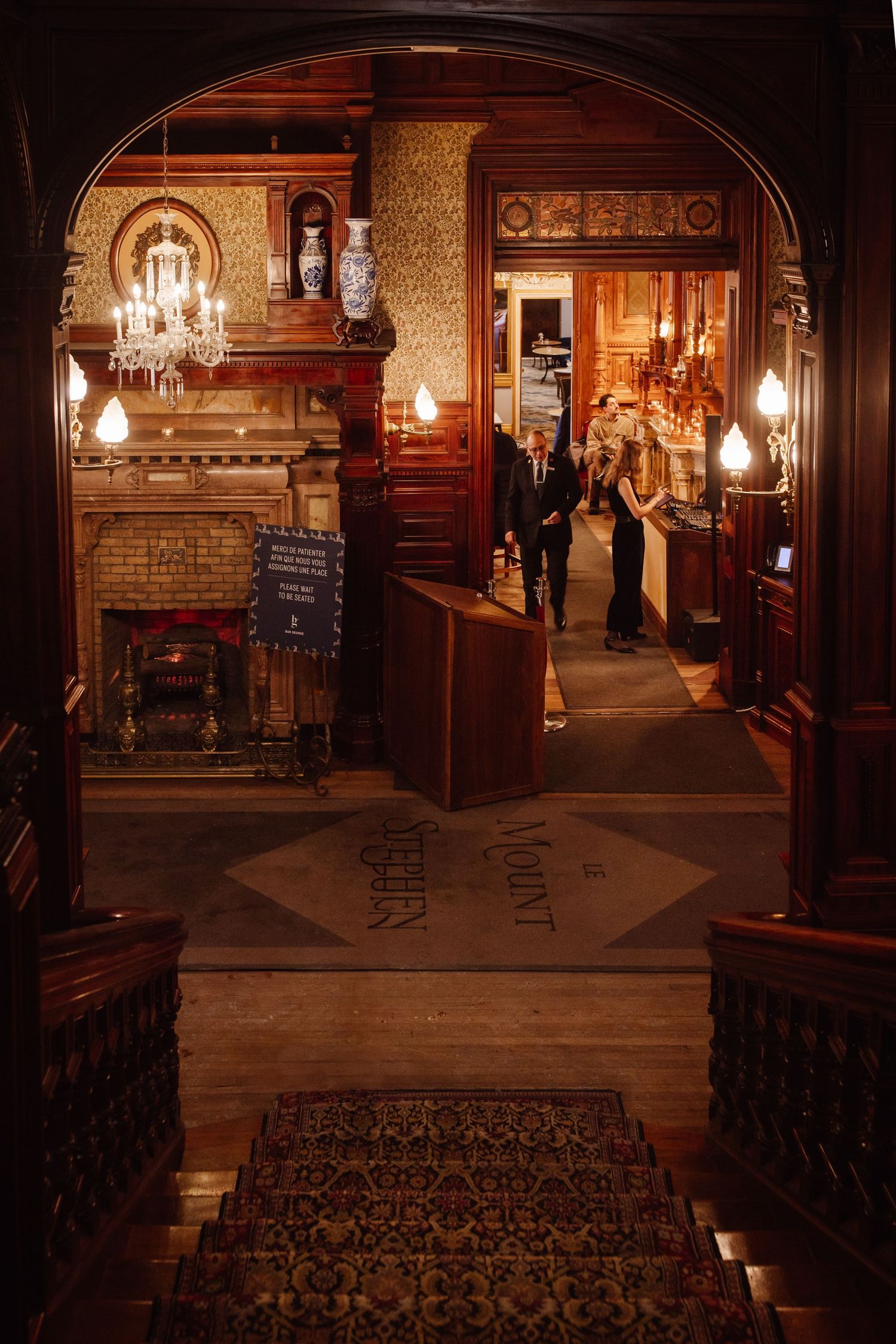Ornate Victorian interior with chandelier and wooden archway in historic building.