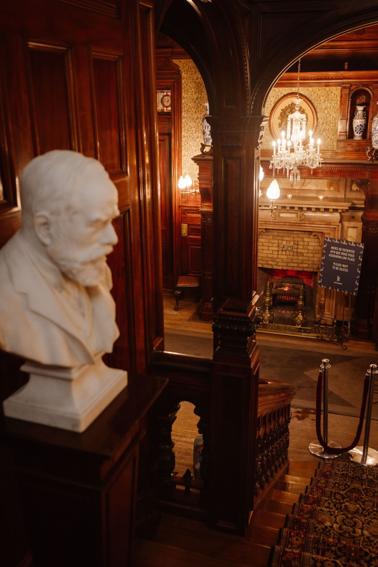 Marble bust and ornate woodwork in historic Victorian building interior.