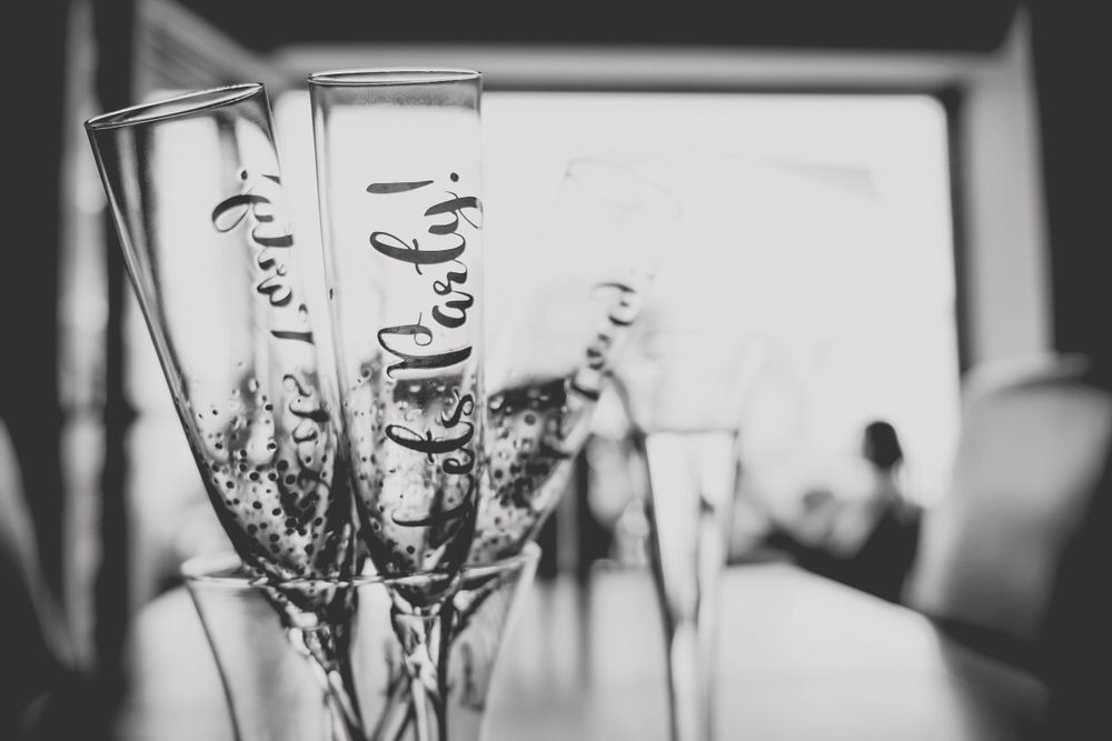 Black and white photo of champagne flutes with decorative text.
