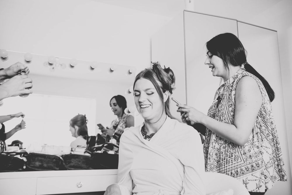 Black and white image of salon appointment with stylist working on client's updo.