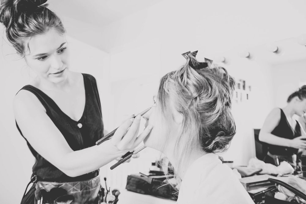Black and white photo of professional hairstylists working on an elegant updo.
