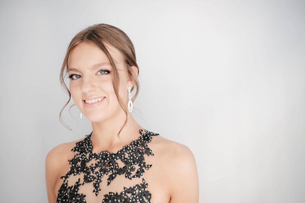 Close up portrait showcasing delicate floral lace detailing on a formal dress neckline.