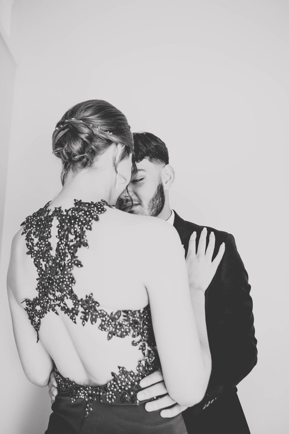 Black and white artistic portrait showing the intricate back detail of a formal dress.