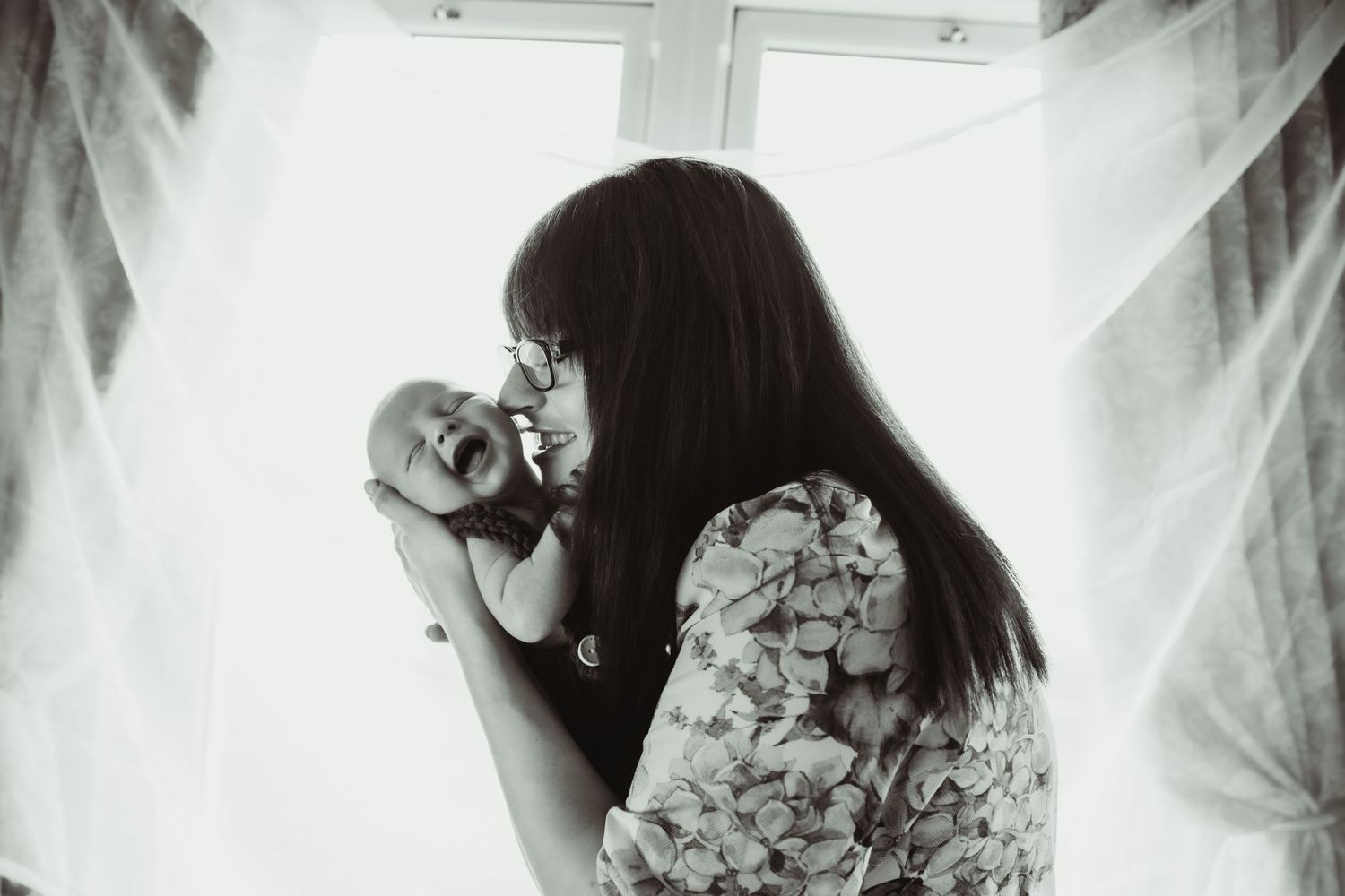 Mother holding smiling newborn son