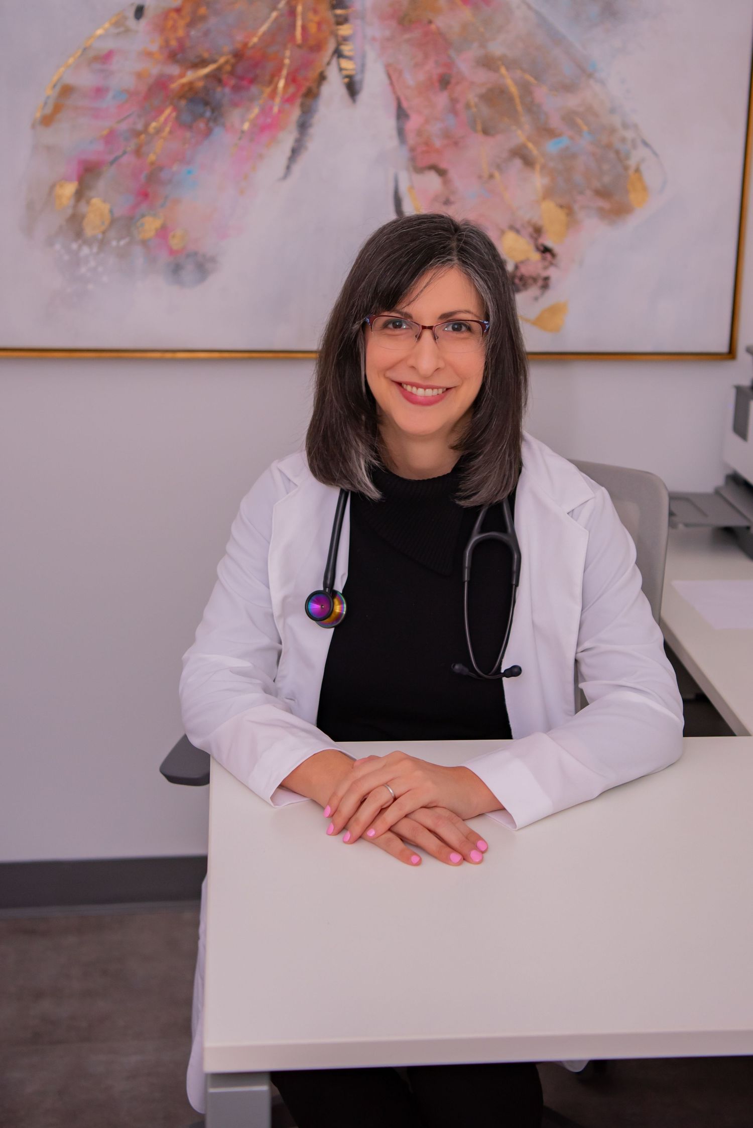 woman physician sitting at desk in white coat kirsten lin