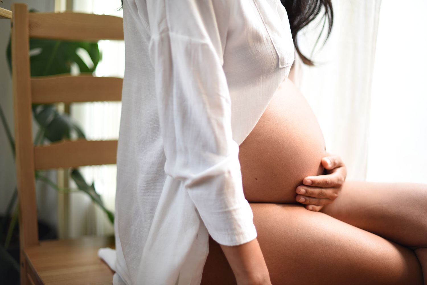 Elegant maternity boudoir photo with white button-down shirt.
