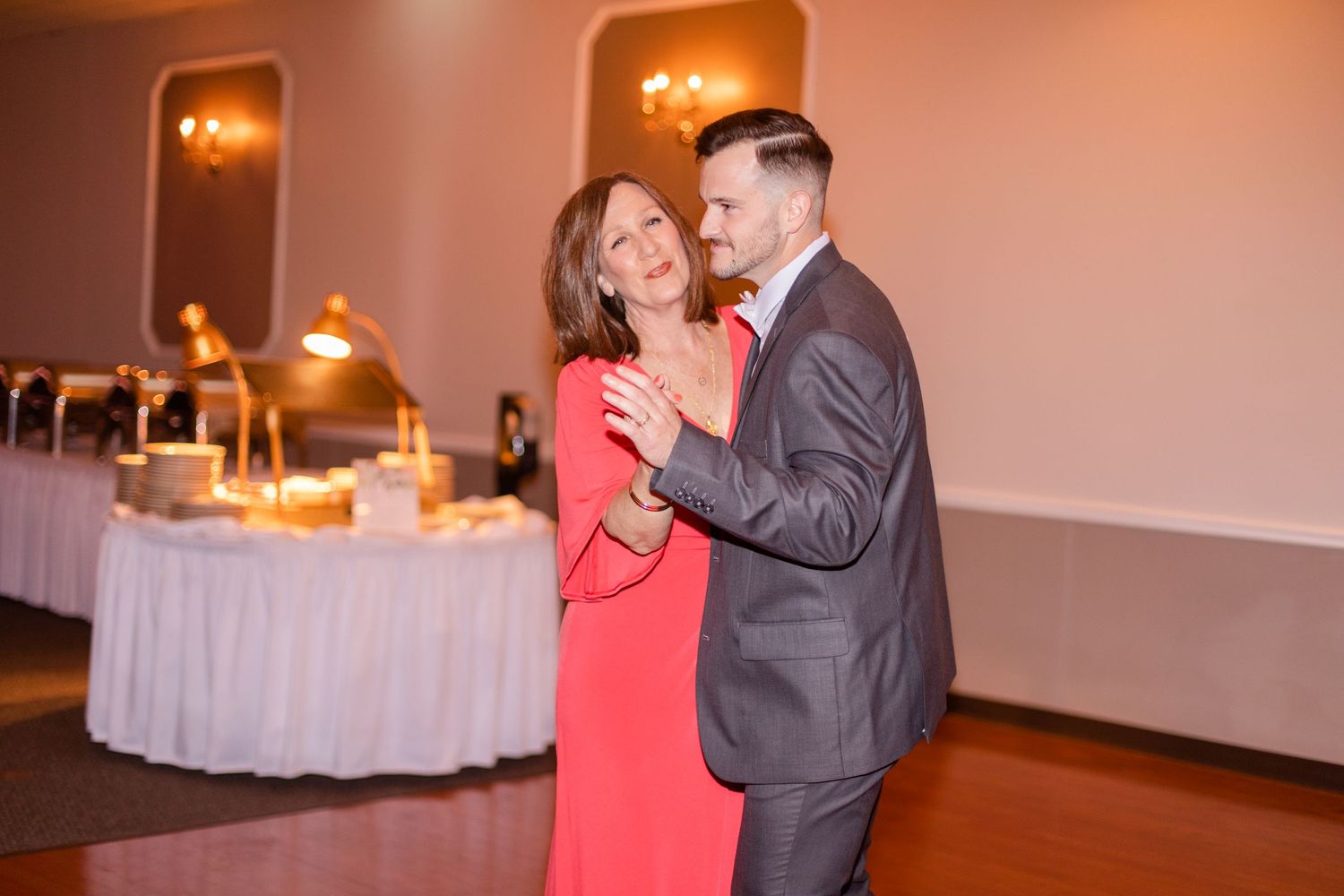Wedding guests dancing and celebrating on the reception dance floor.