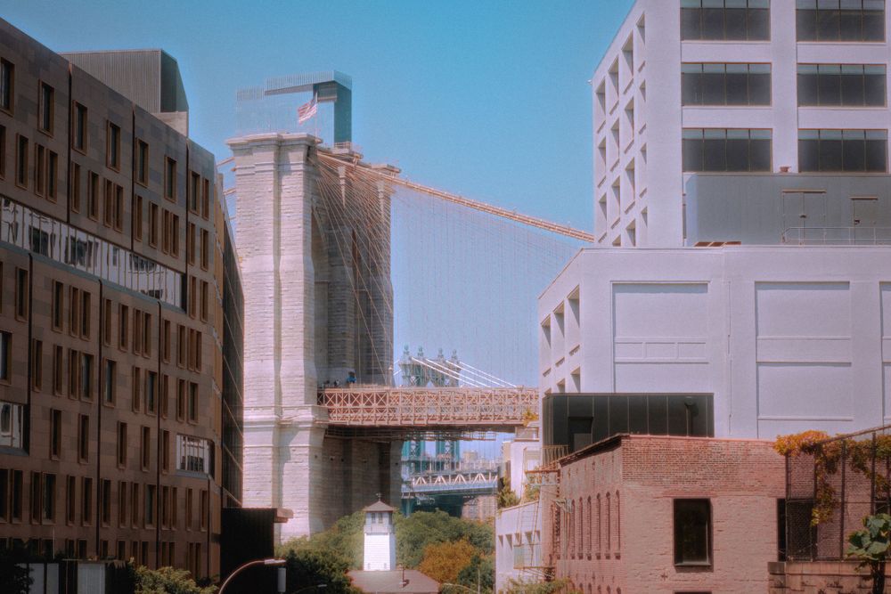 Urban skybridge connecting two buildings in a city landscape.