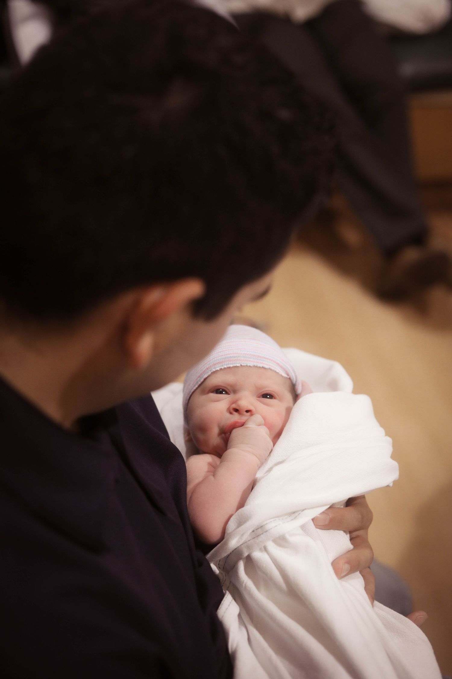 Tucson newborn photographer captures father holding his swaddled newborn baby during Fresh 48 hospital session.