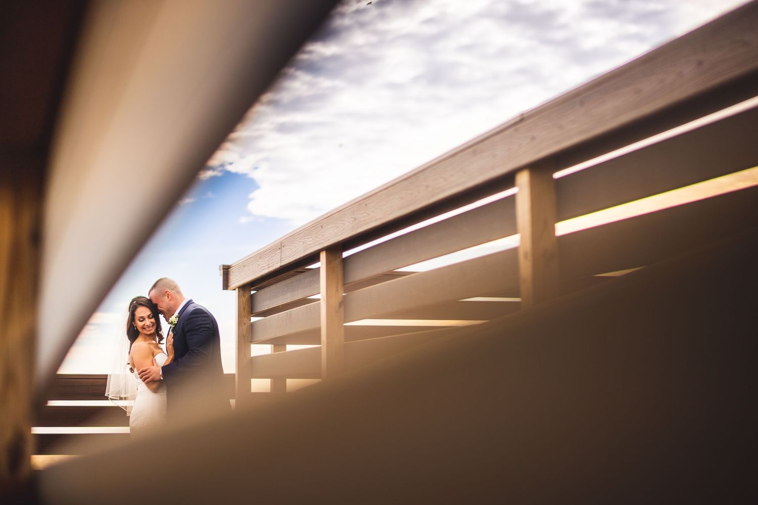 Married couple portrait through fence line