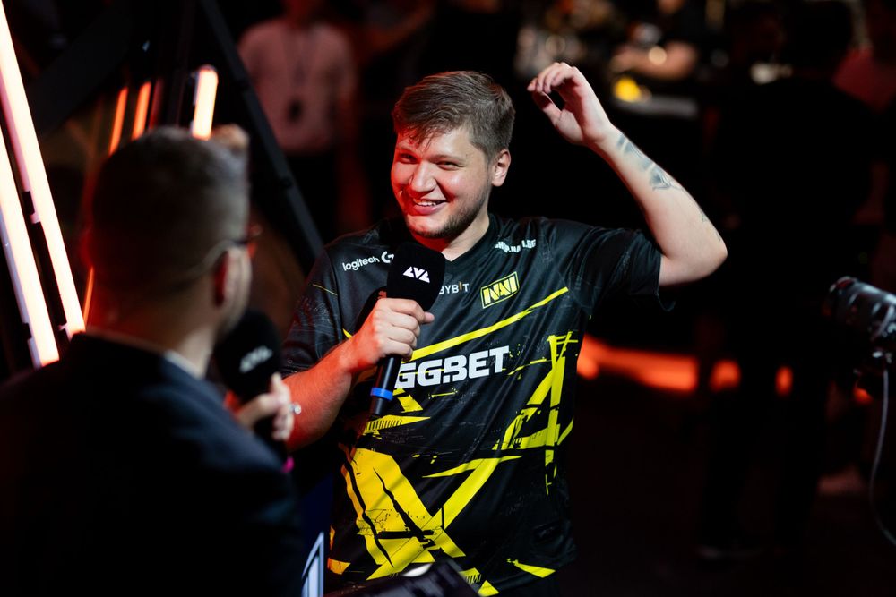 Professional esports player shown smiling during a competitive gaming event while wearing a Na'Vi team jersey.