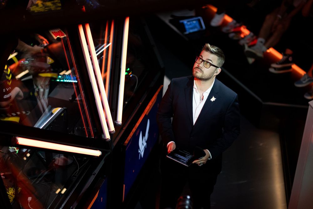A dark studio environment with glowing red neon lights and reflective surfaces creating a dramatic atmosphere.