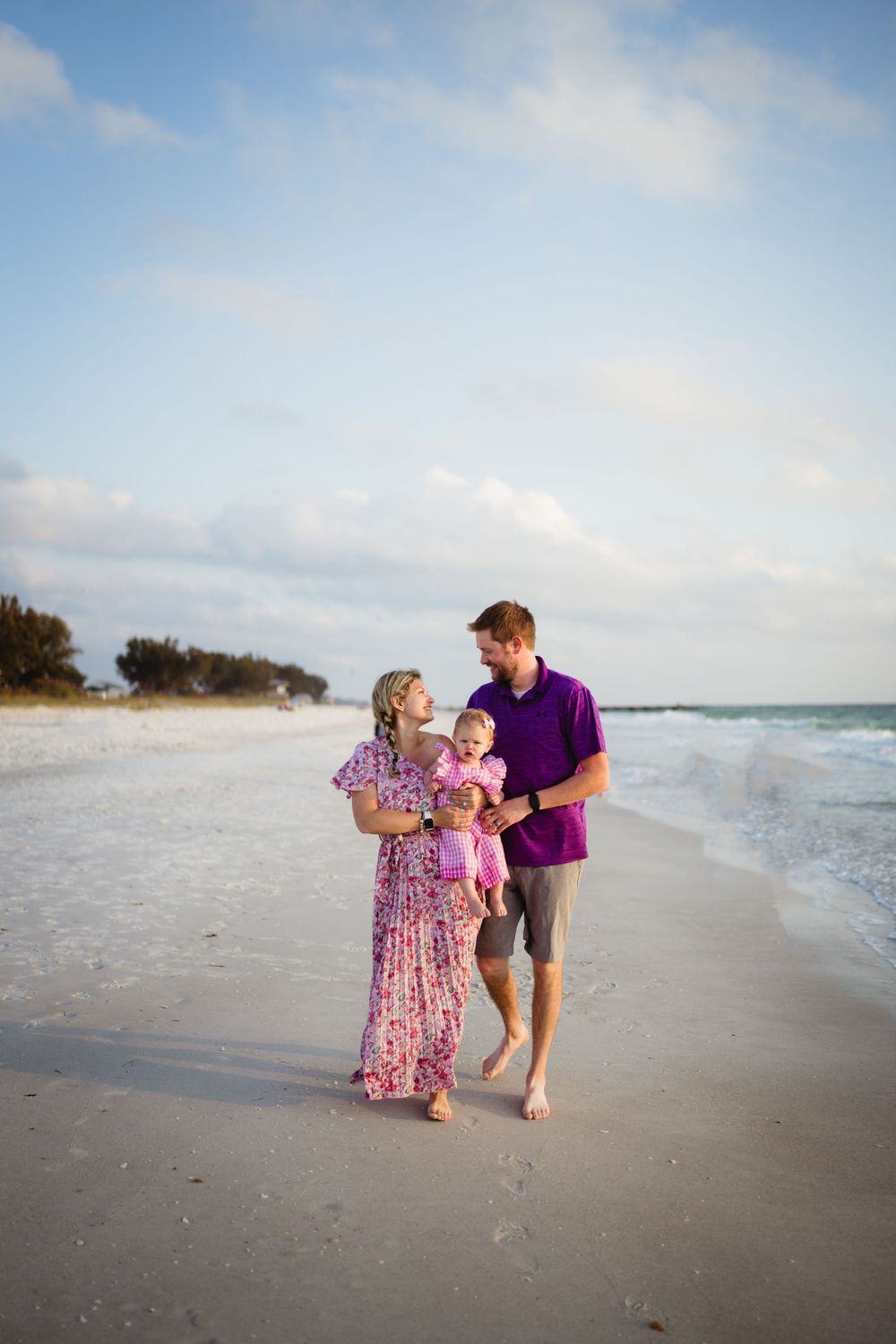 A family strolling together along a serene beach shoreline.