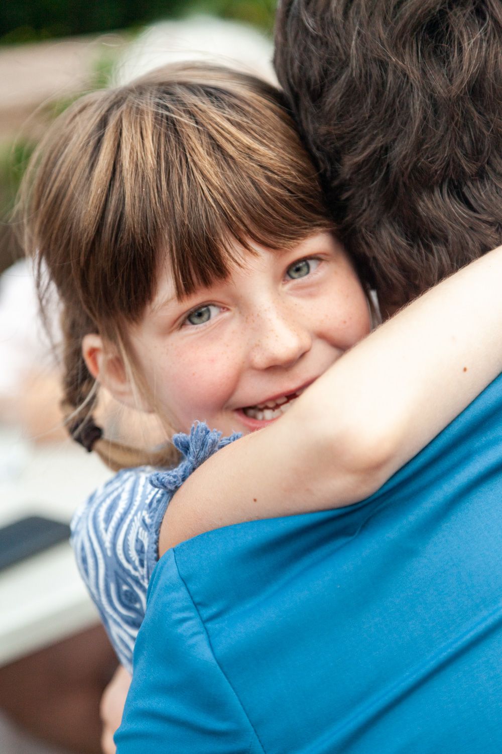 A joyful embrace captured in closeup showing warmth and affection between two people in casual clothing.