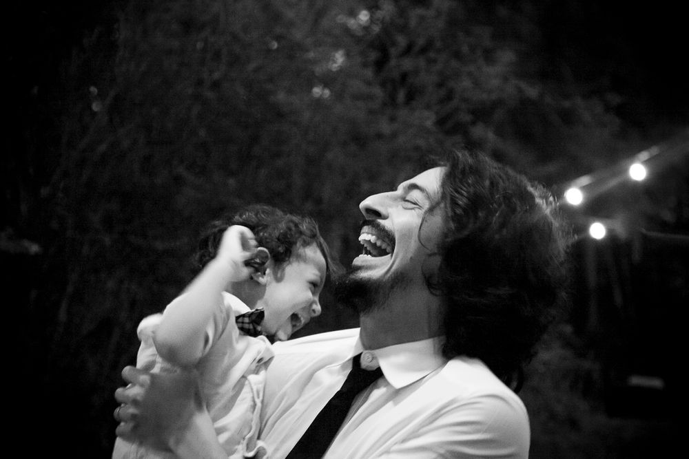A joyful moment captured in black and white as a parent and child laugh together outdoors at night.
