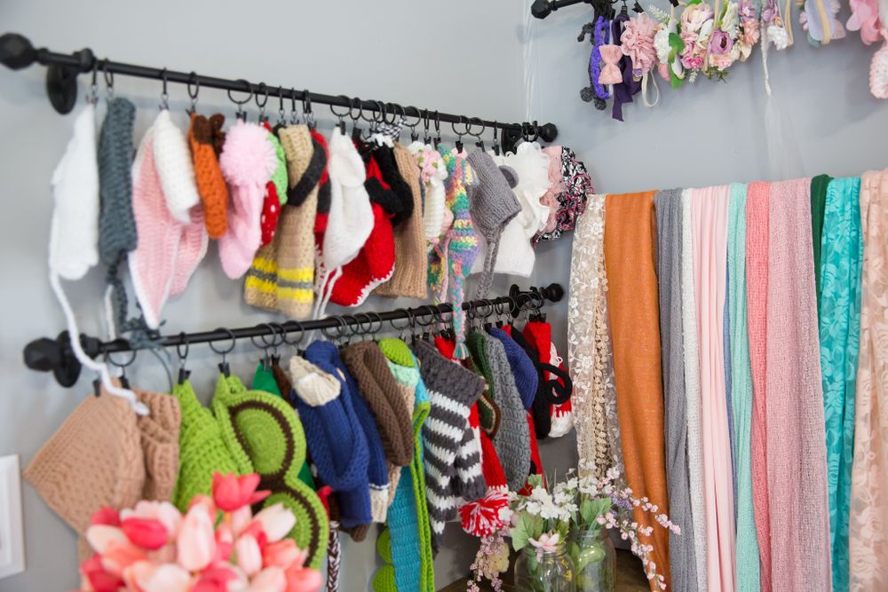 Clothing rack with colorful costumes and fabric backdrops organized in a photography studio corner.