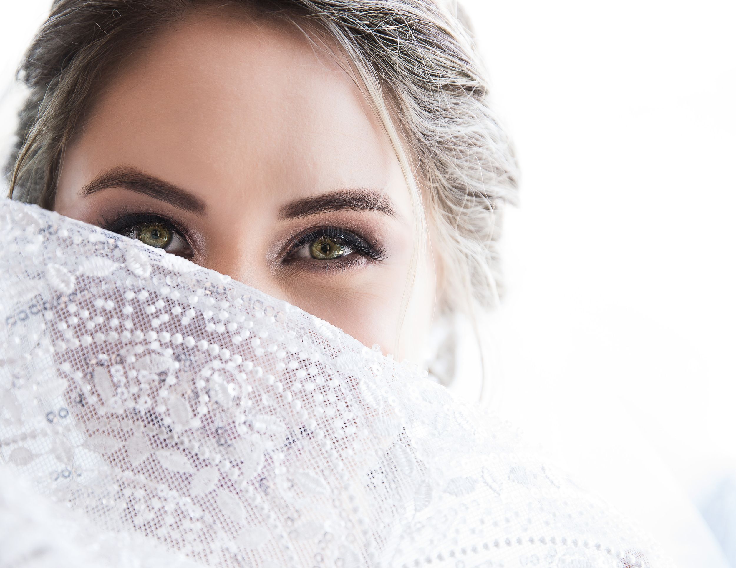 Close-up bridal portrait with intricate lace veil detail.