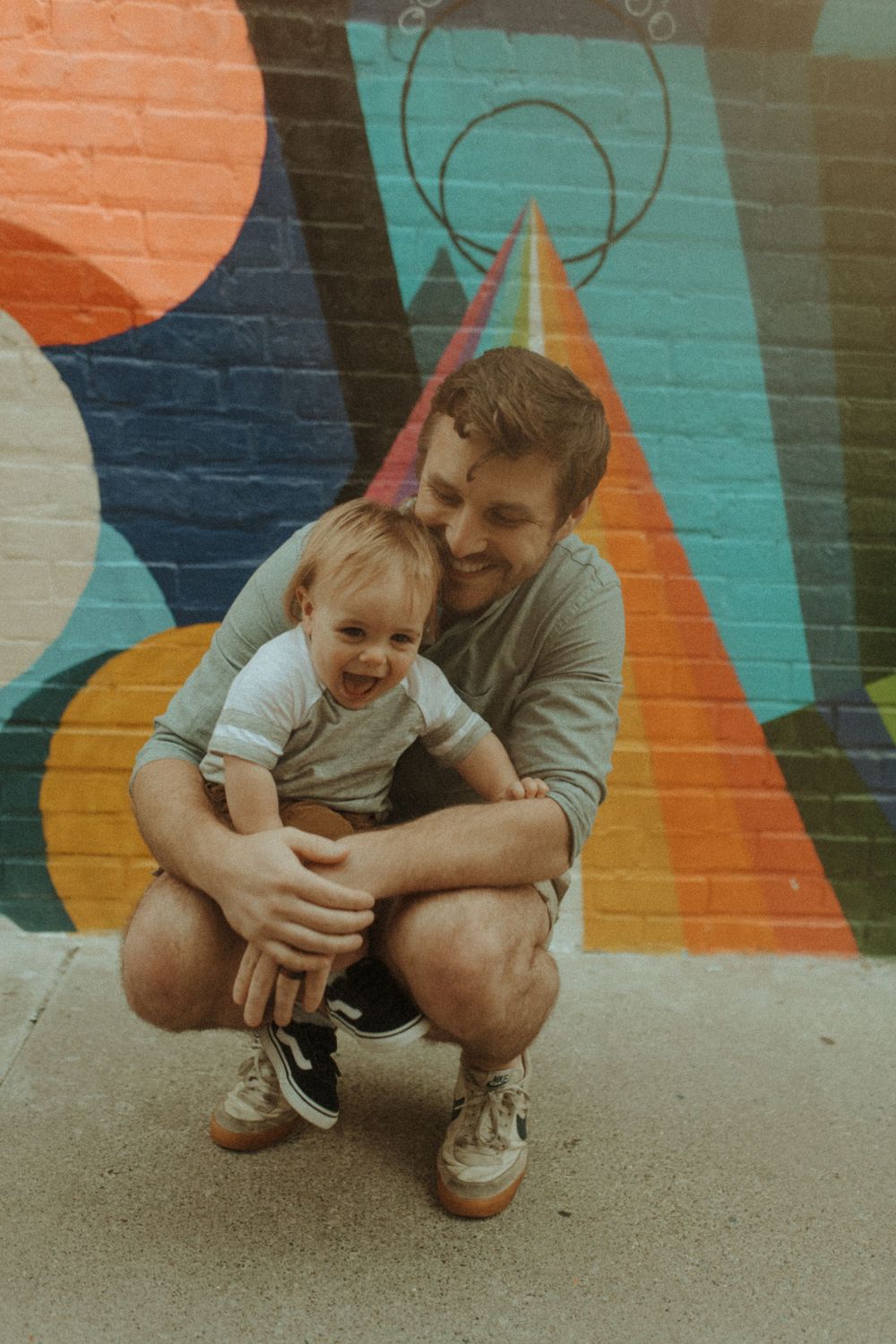 Joyful interaction against colorful geometric street art backdrop.