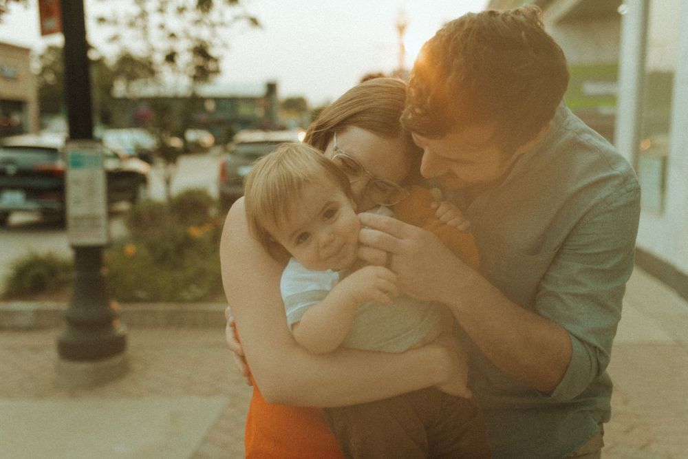 A tender family embrace captured in warm sunset lighting.