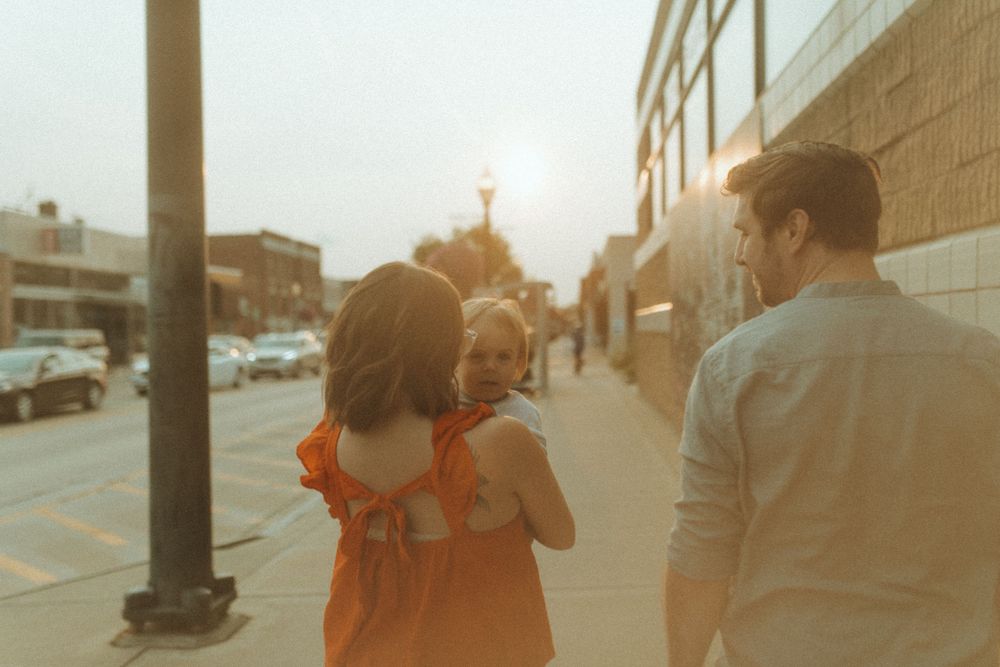 Family walking together on urban street at golden hour.