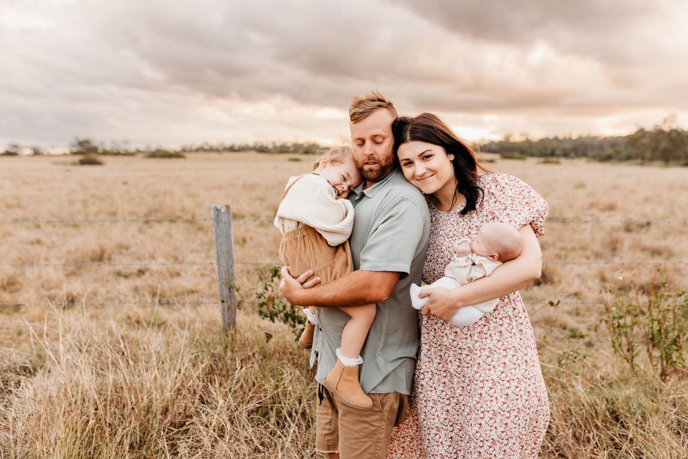 A family portrait in a rustic field during golden hour.