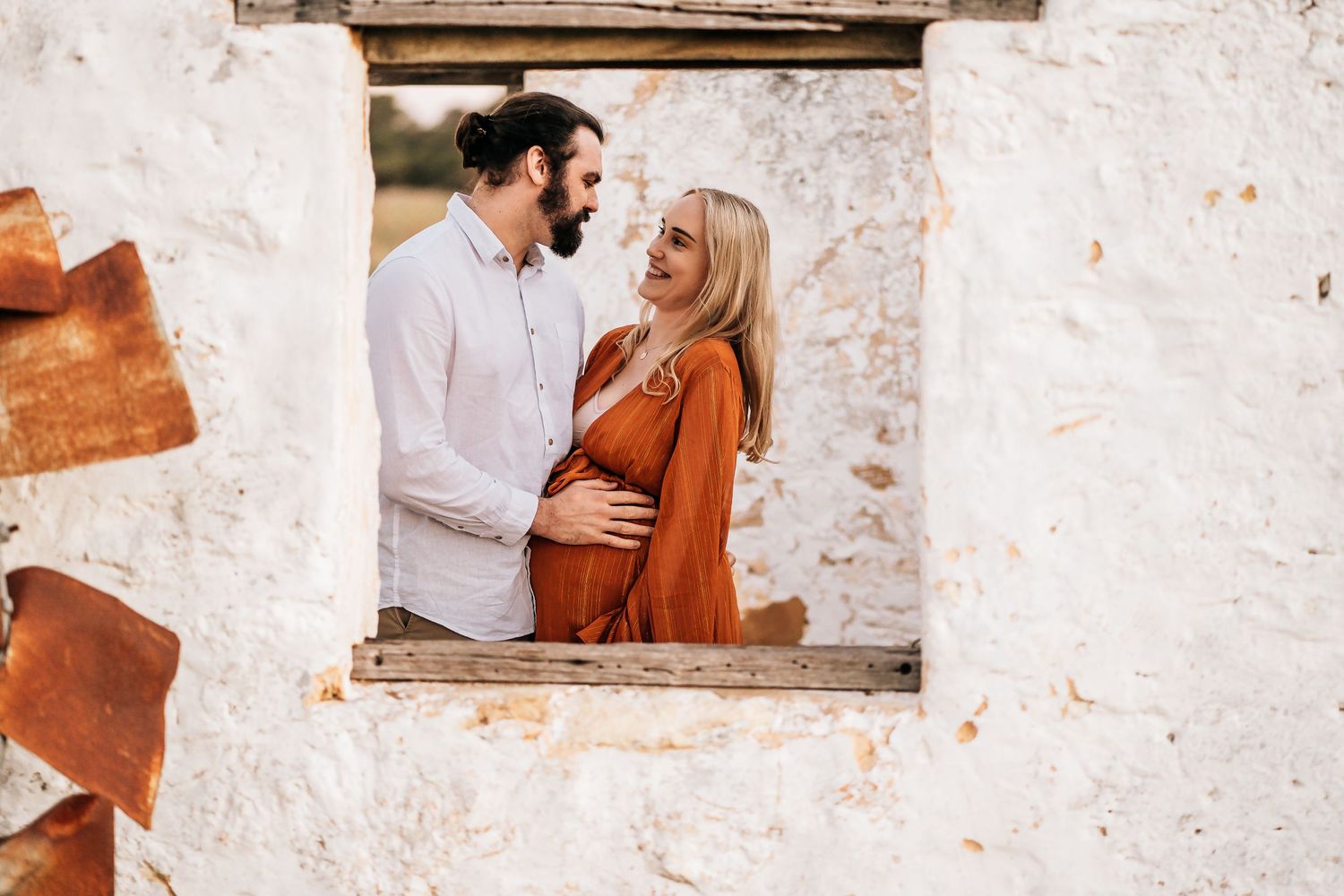 A tender moment captured through a rustic window frame.