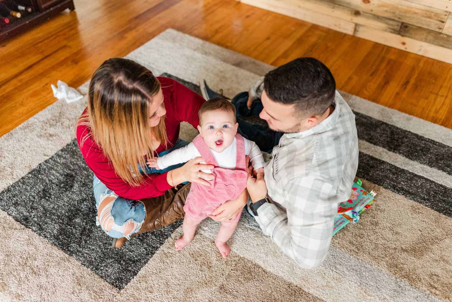Lifestyle family photoshoot in the home with mom and dad on floor with 6 month old baby in Gibsonia, Pennsylvania
