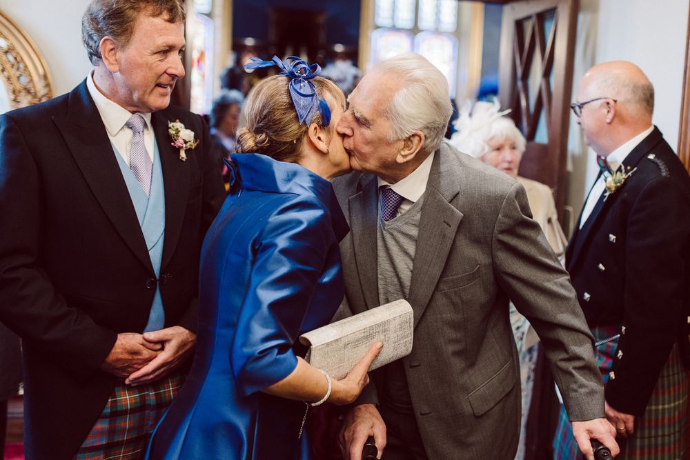 Guests mingling at an elegant indoor reception with formal attire.