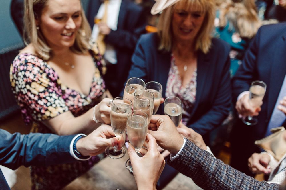 People toasting with champagne glasses at an indoor celebration.