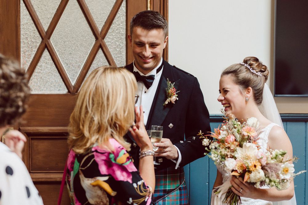 Wedding party members sharing embraces during a reception celebration.