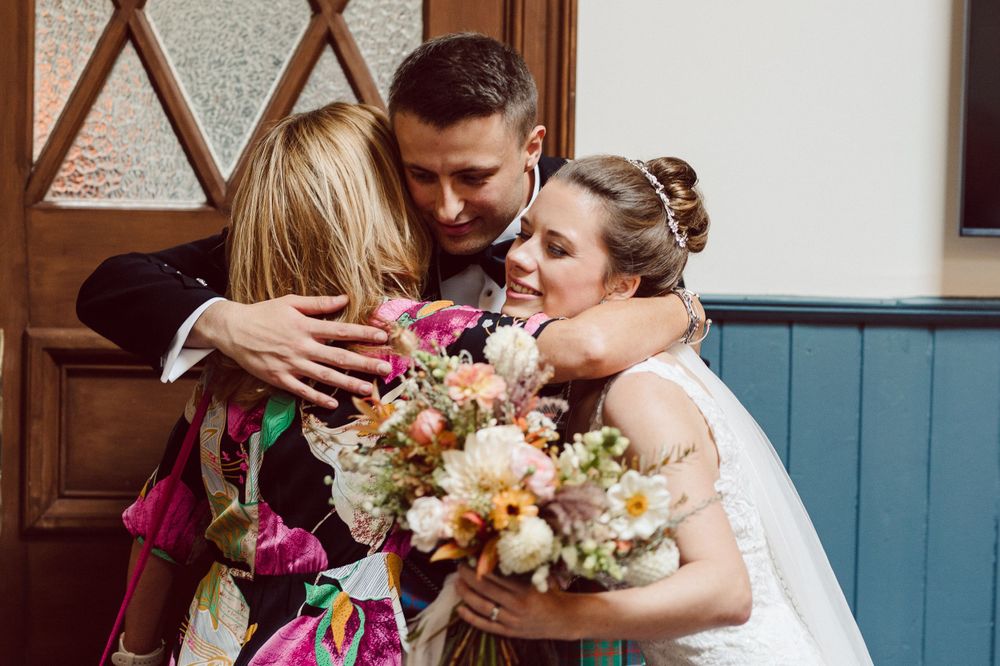 Celebratory moment captured during a wedding reception with floral bouquets.