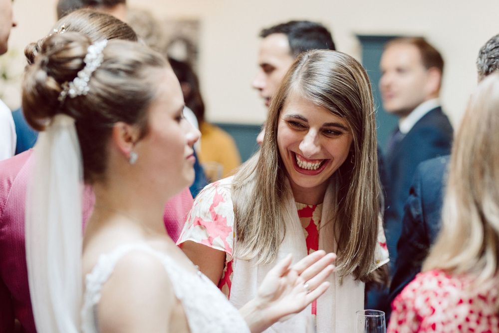 Wedding guests mingling and socializing during an indoor reception event.