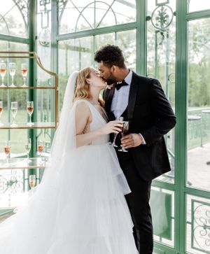 Intimate wedding moment captured inside a sunlit mint green conservatory.