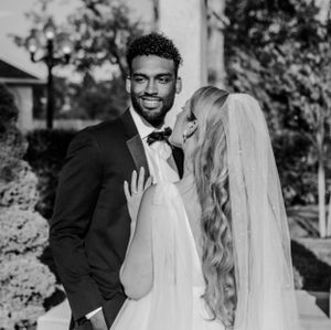 Black and white wedding portrait showcasing intimate moment between newlyweds.